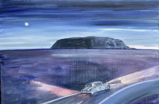 A citroen goddess car driving at night past Uluru