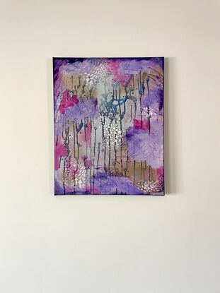 An image of a canvas full of dark hues of purple and navy with hints of magenta acrylic, covered in gold spray paint mixed with water