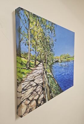 A medium landscape painting of the path beside the river Torrens. The river and the sky is a vivid blue, the grass and reeds are a bright green. There are gum trees to the left of the path. 