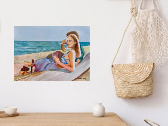 artwork which is the image of a couple sitting sipping red wine on the beach