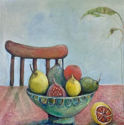 A brightly coloured bowl of fruit sits on a table, Fruit includes pears, lemons, figs. In front to the right is half a lemon. Bowl is turquoise and green