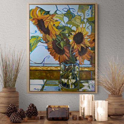 Sunflowers in glass vase on window ledge.