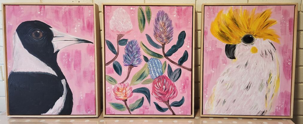 3 canvas's with pink backgrounds. One featuring Australian magpie, one with native flowers and one with a white and yellow cockatoo. All canvas's feature a wooden frame around the work.