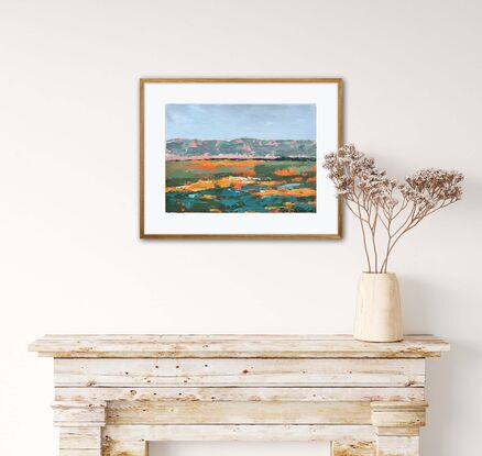 Orange red dirt outback landscape with greenery and mountains in distance 