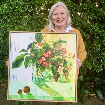 A framed, expressive still life painting of entangled flora in greens, yellows, reds, pinks and oranges.