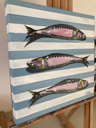 Three sardines on French blue linen striped background