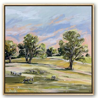 Rolling green hills scattered with grazing sheep. The sky is beginning to turn from pink to blue. Gum trees line the horizon.