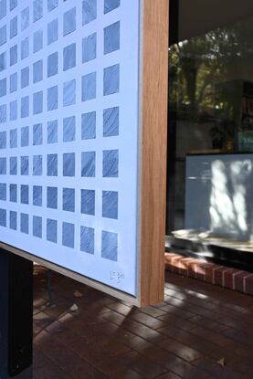 A grid of textured blue, white and grey squares, slightly extruding from the canvas, representing an ocean wave, set against a background of light blue/grey.