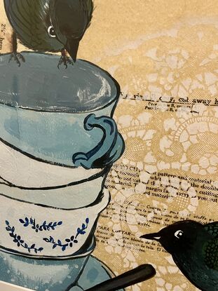 One bird sitting on a stack of tea  cups Looking down at another bird on the ground with a background of vintage dress patterns and dental of Stencil doilies