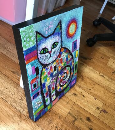 Quirky, colourful , seated cat .