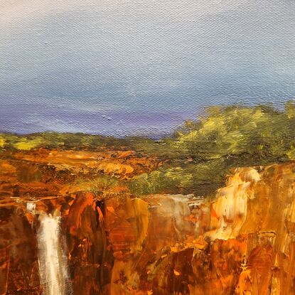 Red escarpment with waterfall