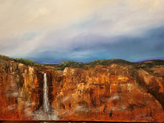 Red escarpment with waterfall