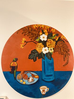 A circular still life  painting in rich orange and contrasting blue?  depicting flowers, rainbow lorikeet birds, a teacup and a small plate with ornaments. 