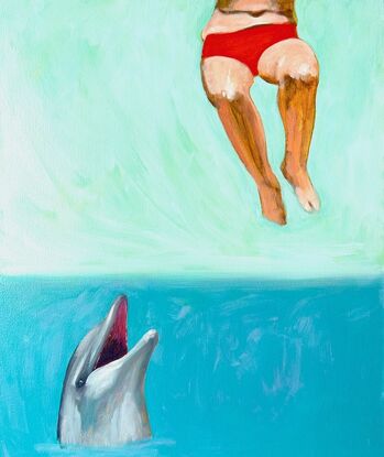 A dolphin looks up from the water as the lower half of a woman in a bikini hangs in the air.