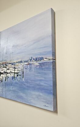 A landscape oil painting of boats at Williamstown in Melbourne, Victoria. The water and sky are blue and the boats are white. Their masts are reflected in the water. The city can be seen in the background.