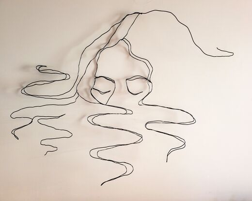 A continuous line drawing sculpture,  made with wire, of a woman with her face half submerged into water. Curls of hair floating around her. 