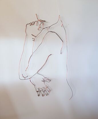 A wire sculpture. Single line drawing of a nude female looking over her shoulder