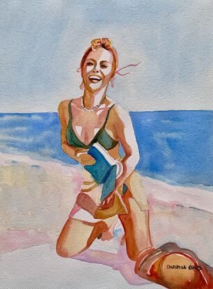 image of woman laughing and smiling widely whilst kneeling on a towel on the beach




