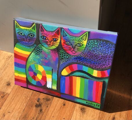 Three abstract, rainbow coloured cats.