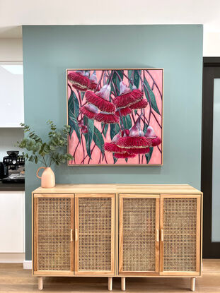 Red Silver princess flowering gum blossoms against a blush pink background and green patterned leaves