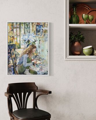 a woman sits at breakfast table writing in her notebook. Behind her a vase of Hydrangeas and light pouring through French doors