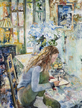 a woman sits at breakfast table writing in her notebook. Behind her a vase of Hydrangeas and light pouring through French doors