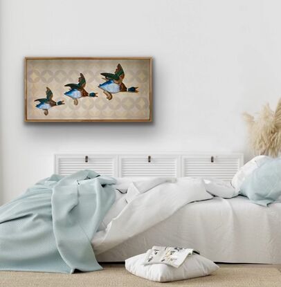 Three ceramic mallard ducks flying across a beige patterned wallpapered wall