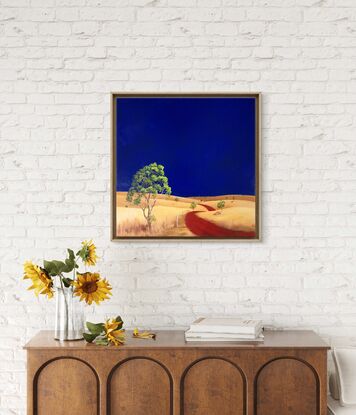 Australian landscape with dark blue sky and gold and yellow highlighted hills and foreground, an orange red road leads out of the painting with trees scatterd throughout,  Lucinda Leveille, original artwork