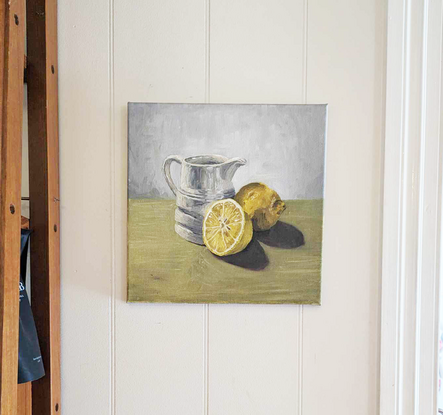 Milk jug and lemons on green 