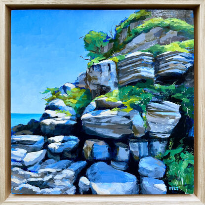 Sunny seaside rock wall with greenery