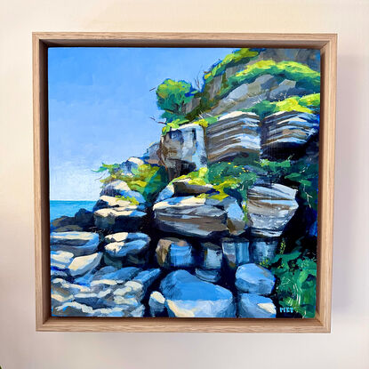 Sunny seaside rock wall with greenery