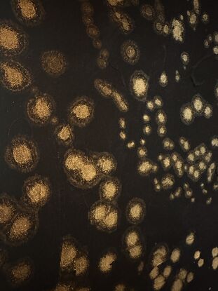 A black canvass with clusters of shimmering gold stars in an abstract impressionist style