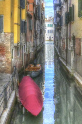 Red boat on canal in Venice, Italy