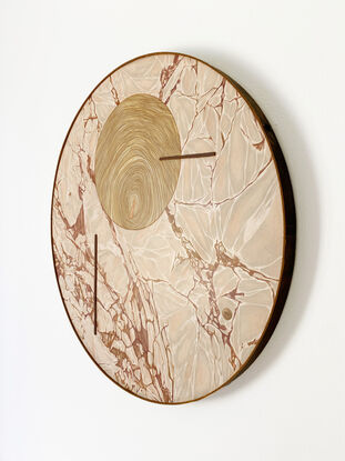 round artwork of pink-grey marble combined with a wooden circle in the top middle part