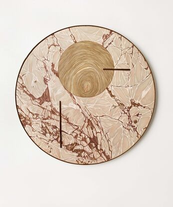 round artwork of pink-grey marble combined with a wooden circle in the top middle part