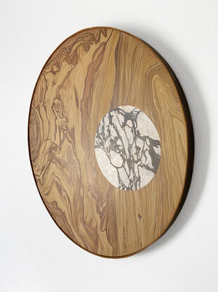 round wooden pattern with a white marble circle inside of it