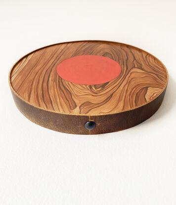 wooden circle with red small circle in the middle