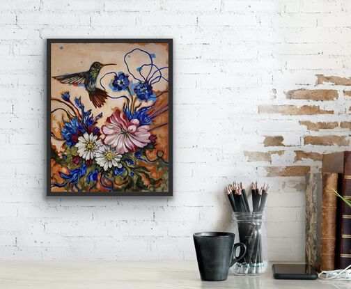 A hummingbird lingers amongst wild flowers of blue, pink and white. With abstract orange background.