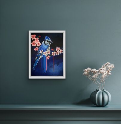 A blue jay bird perched on a magnolia tree branch against an indigo blue background. 