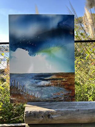 Under an inky skyscape, the tidal movements of the sea and weathered old posts are seen.