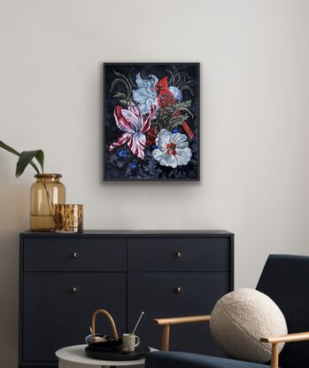 Red cardinal sits among flowers and vines with white  flowers and blue flower and striped red and white tulip on black and grey patterned ground 