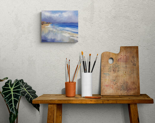 Seascape with distant headland and gentle waves reaching into the shore.  There is a small figure in the distance walking in the shallow water.