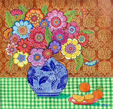 Colourful flowers in blue and white vase in front of red ochre patterned background on green checkered tablecloth with a pink plate of oranges.