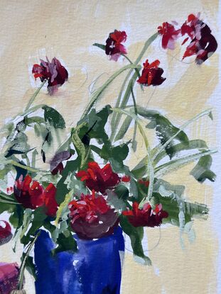 Backlit Red dahlias in a dark vase with a bowl of apples casting a shadow forward