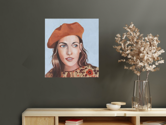 Woman wearing  orange beret and  floral shirt.