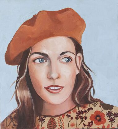 Woman wearing  orange beret and  floral shirt.