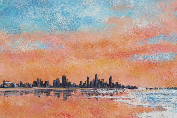 Sunrise over a beach with waves and hi-rise buildings.