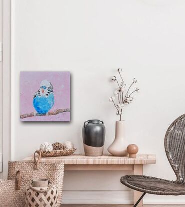 A thickly textured oil painting of a colourful budgerigar with bright blue and white feathers, perched on a  branch. The background is a soft pink, which contrasts nicely with the vibrant colour of the bird.