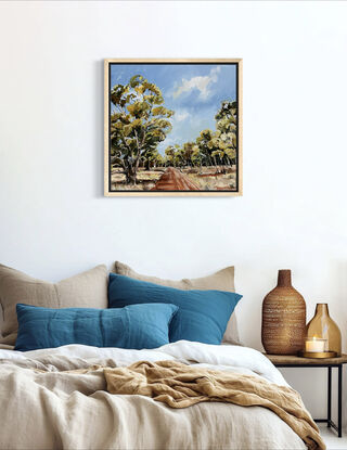 A red track is bordered by swaying gumtrees that make an archway. The blue sky is dotted with clouds. 