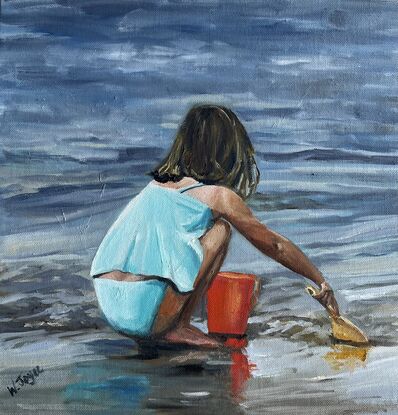 A girl in turquoise bathers squats on the edge of the ocean filling a red bucket with sand 